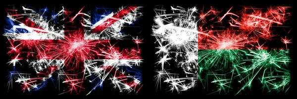 Nagy-Britannia, Egyesült Királyság vs Madagaszkár, Madagaszkár Újév ünneplés utazás pezsgő tűzijáték zászlók koncepció háttér. Két elvont állapot kombinációja zászló. — Stock Fotó