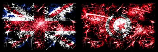 Velká Británie, Velká Británie vs Tunisko, Tunisko Silvestr oslavy cestování jiskřící zábavní pyrotechnika vlajky koncept pozadí. Kombinace dvou abstraktních stavových příznaků. — Stock fotografie