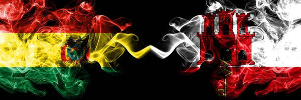 Bolivia, Boliviano vs Gibilterra fumoso mistici stati bandiere poste fianco a fianco. Concetto e idea di spessore colorato seta bandiere fumo astratto — Foto Stock