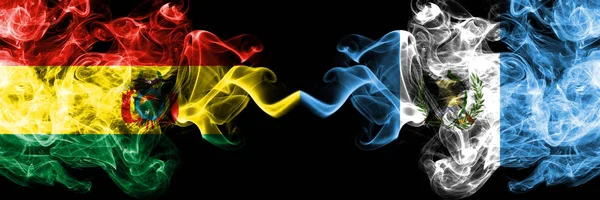 Bolivia, Bolivia contro Guatemala, stati mistici fumé guatemaltechi bandiere affiancate. Concetto e idea di spessore colorato seta bandiere fumo astratto — Foto Stock