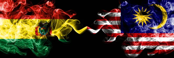 Bolívie, Bolívie vs Malajsie, Malajsie, malajské kouřové mystické státy vlajky umístěné bok po boku. Koncept a myšlenka tlusté barevné hedvábné abstraktní kouřové vlajky — Stock fotografie