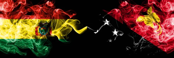 Bolívia, Bolívia vs Pápua Új-Guinea füstös misztikus államok zászlók egymás mellett. Koncepció és ötlet vastag színű selymes elvont füst zászlók — Stock Fotó