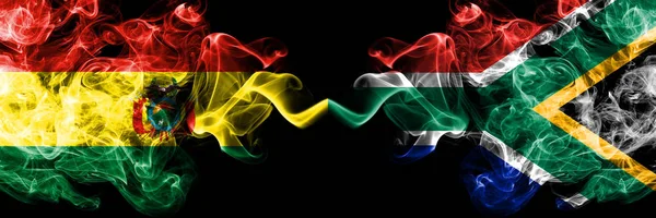 Bolivia, Bolivia vs Zuid-Afrika, Afrikaanse rokerige mystieke staten vlaggen naast elkaar geplaatst. Concept en idee dik gekleurde zijdeachtige abstracte rook vlaggen — Stockfoto