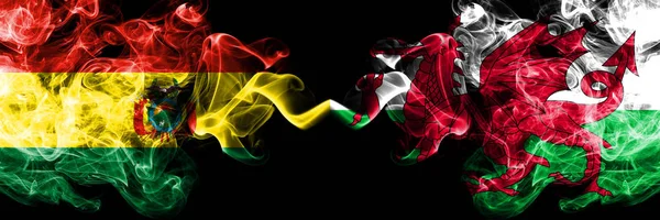 Βολιβία, Βολιβία εναντίον Ουαλίας, Ουαλίας καπνιστής μυστικιστικές πολιτείες σημαίες τοποθετούνται δίπλα-δίπλα. Έννοια και ιδέα παχιά χρωματιστά μεταξένια αφηρημένα σημαίες καπνού — Φωτογραφία Αρχείου