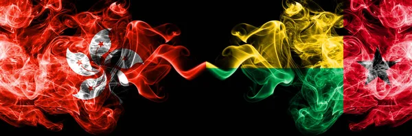 Hong Kong, China vs Guinea Bissau smoky mystic states flags placed side by side. Concept and idea thick colored silky abstract smoke flags — Stock Photo, Image