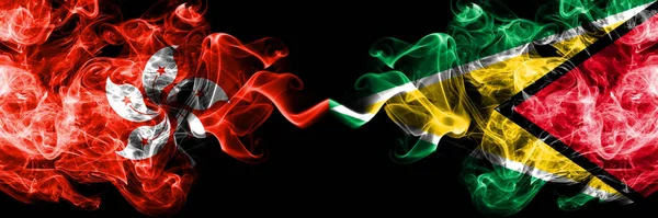 Hong Kong, Cina contro Guyana, stati mistici fumè guyanesi bandiere poste fianco a fianco. Concetto e idea di spessore colorato seta bandiere fumo astratto — Foto Stock