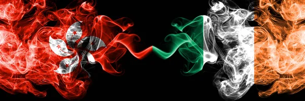 Hong Kong, China vs Irlanda, Estados místicos ahumados irlandeses banderas colocadas una al lado de la otra. Banderas de humo abstractas sedosas de color grueso concepto e idea — Foto de Stock