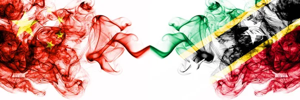 China, China vs Saint Kitts und nevis rauchigen mystischen Staaten Flaggen nebeneinander platziert. Konzept und Idee dicke farbige seidig abstrakte Rauchfahnen — Stockfoto