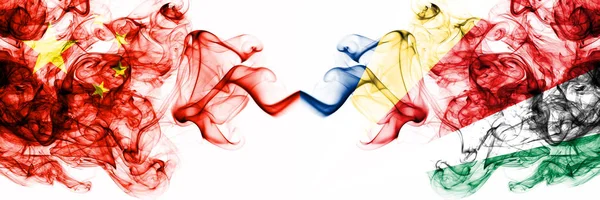 China, China vs Seychellen, seychelloise rauchige mystische Staaten Flaggen nebeneinander platziert. Konzept und Idee dicke farbige seidig abstrakte Rauchfahnen — Stockfoto