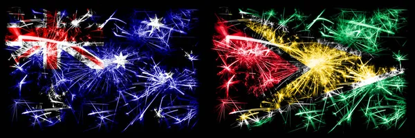 澳大利亚，Ozzie对圭亚那，圭亚那新年庆祝闪耀的烟花旗帜概念背景。 两种抽象状态标志的组合. — 图库照片