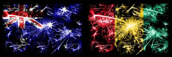 Australia, Ozzie vs Guinea, Guinean New Year celebration sparkling fireworks flags concept background. Combination of two abstract states flags. — Stock Photo, Image