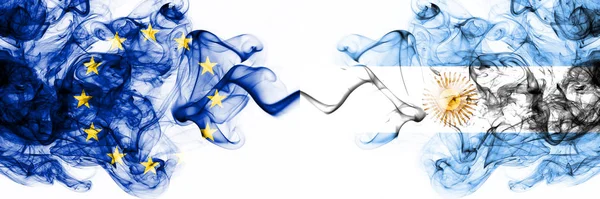 Europa, Europeiska unionen kontra Argentina, argentinska rökiga mystiska flaggor placerade sida vid sida. Tjock färgad silkeslen abstrakt rök flaggor kombination — Stockfoto