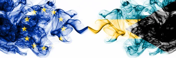 Eu, Unión Europea vs Bahamas, Bahamas banderas místicas ahumadas colocadas una al lado de la otra. Combinación de banderas de humo abstractas sedosas de color grueso — Foto de Stock