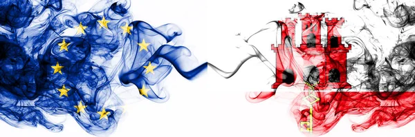 Europa, Europeiska unionen mot Gibraltar rökiga mystiska flaggor placerade sida vid sida. Tjock färgad silkeslen abstrakt rök flaggor kombination — Stockfoto
