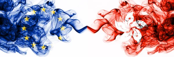 Eu, European Union vs Hong Kong, China rokerige mystieke vlaggen naast elkaar geplaatst. Dikke gekleurde zijdeachtige abstracte rookvlaggen combinatie — Stockfoto