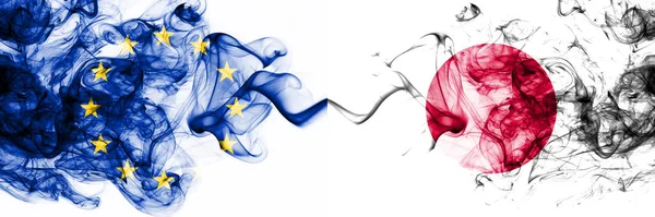 Eu, Europese Unie vs Japan, Japanse rokerige mystieke vlaggen naast elkaar geplaatst. Dikke gekleurde zijdeachtige abstracte rookvlaggen combinatie — Stockfoto