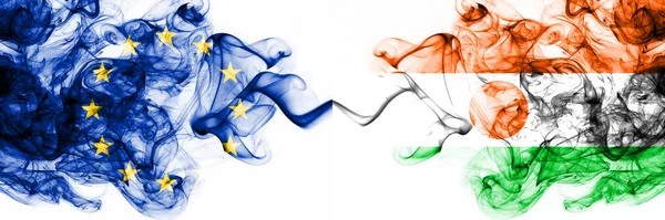 Europa, Europeiska unionen mot Niger, Nigerias rökiga mystiska flaggor placerade sida vid sida. Tjock färgad silkeslen abstrakt rök flaggor kombination — Stockfoto