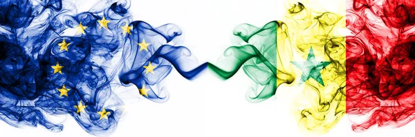 Eu, European Union vs Senegal, Senegalese rokerige mystieke vlaggen naast elkaar geplaatst. Dikke gekleurde zijdeachtige abstracte rookvlaggen combinatie — Stockfoto