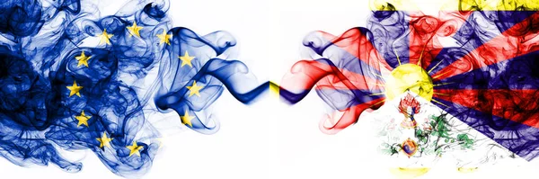 Europa, Europeiska unionen mot Tibet, tibetanska rökiga mystiska flaggor placerade sida vid sida. Tjock färgad silkeslen abstrakt rök flaggor kombination — Stockfoto
