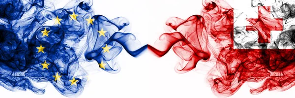 Europa, Europeiska unionen mot Tonga, tongan rökiga mystiska flaggor placerade sida vid sida. Tjock färgad silkeslen abstrakt rök flaggor kombination — Stockfoto