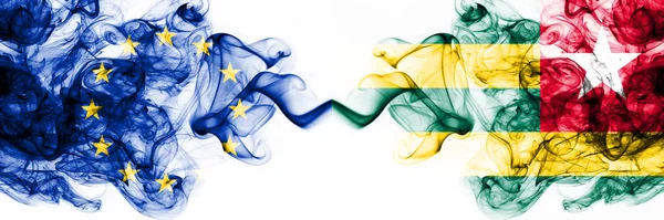 Eu, European Union vs Togo, Togolese rokerige mystieke vlaggen naast elkaar geplaatst. Dikke gekleurde zijdeachtige abstracte rookvlaggen combinatie — Stockfoto