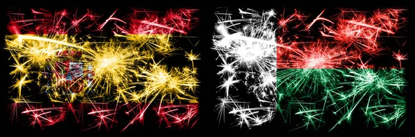 Spanish vs Madagascar, Madagascan New Year celebration sparkling fireworks flags concept background. 두 개의 추상 국가가 결합 된 깃발. — 스톡 사진