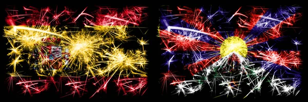 Spanisch vs Tibet, tibetische Neujahrsfeier funkelnden Feuerwerk Flaggen Konzept Hintergrund. Kombination aus zwei abstrakten Staaten Flaggen. — Stockfoto