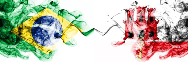 Brazil, Brazilian vs Gibraltar smoky mystic flags placed side by side. Thick colored silky abstract smoke flags combination — Stock Photo, Image