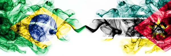 Brazylia, Brazylijczyk vs Mozambik, Mozambik smoky mistyczne flagi umieszczone obok siebie. Grube kolorowe jedwabiste abstrakcyjne połączenie flag dymu — Zdjęcie stockowe