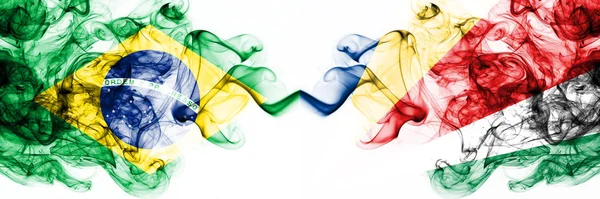 Brésil, Brésil vs Seychelles, Seychelloise Drapeaux mystiques fumés placés côte à côte. Combinaison de drapeaux de fumée abstraits soyeux de couleur épaisse — Photo