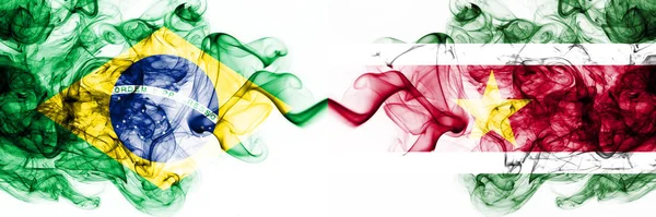 Brazil, Brazilian vs Suriname, Surinamese smoky mystic flags placed side by side. Thick colored silky abstract smoke flags combination