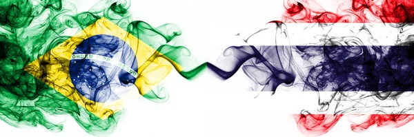 Бразилія, Бразилія проти Таїланду, тайський димний містичний прапор розміщений пліч-о-пліч. Товсті кольорові сріблясті абстрактні димові прапори комбінують — стокове фото
