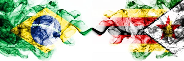 Brazylia, Brazylia vs Zimbabwe, Zimbabwe smoky mistyczne flagi umieszczone obok siebie. Grube kolorowe jedwabiste abstrakcyjne połączenie flag dymu — Zdjęcie stockowe