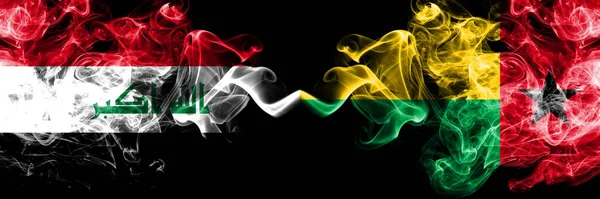 이라크 기니비사우와 이라크 미스틱 깃발을 나란히 색조의 누르스름 연기가 오르는 — 스톡 사진