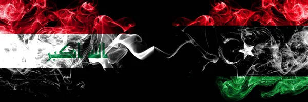 イラク イラク対リビア リビアの煙霧の神秘的な旗が並んで配置されます 濃い色の絹のような煙のフラグを一緒に — ストック写真