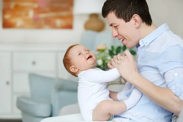 Un padre feliz jugando con un bebé adorable en el dormitorio. Papi e hija — Foto de Stock