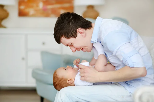 Un padre feliz jugando con un bebé adorable en el dormitorio. Papi e hija — Foto de Stock