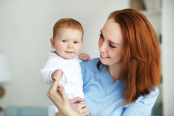 Mujer bonita sosteniendo a un bebé recién nacido sonriente en sus brazos. Madre e hija. — Foto de Stock