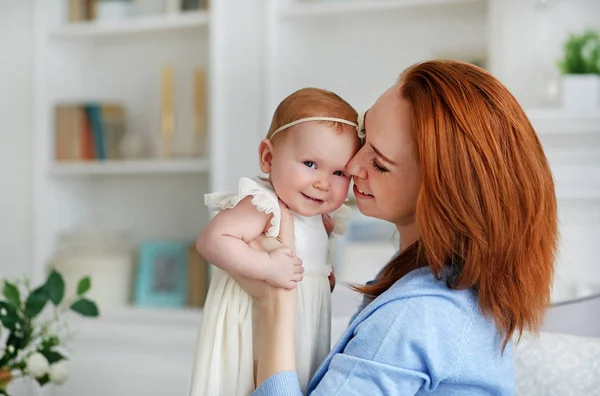 Mujer bonita sosteniendo a un bebé recién nacido sonriente en sus brazos. Madre e hija. — Foto de Stock