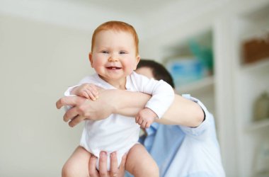 Bebek yatak odasında oynamaktan mutlu baba