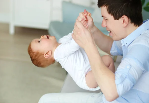 Un padre feliz jugando con un adorable bebé en el dormitorio — Foto de Stock