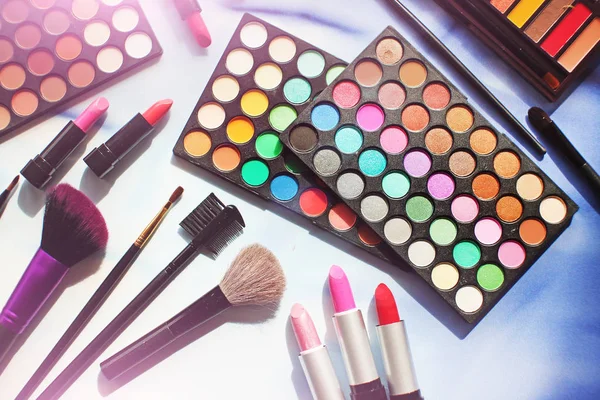 Professional make up set: eyeshadow palette, lipstick, make-up brushes and many cosmetics close up. Film and flare effect Top view, flatlay