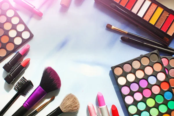 Professionelles Make-up mit Copyspace: Lidschattenpalette, Lippenstift, Make-up-Pinsel und viele Kosmetika aus nächster Nähe. Film und Flare-Effekt. Ansicht von oben, flach — Stockfoto