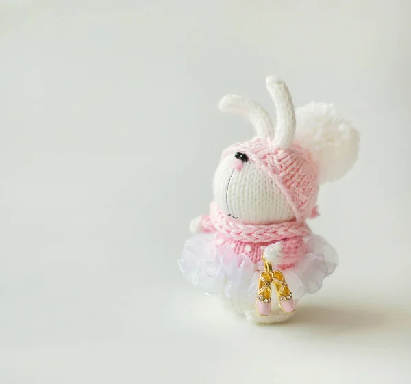 Handmade knitted rabbit. Easter Bunny ballet dancer in pink dress with Pointe shoes in paw on white background Royalty Free Stock Photos