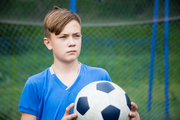 Rapaz com uma bola a jogar futebol — Fotografia de Stock