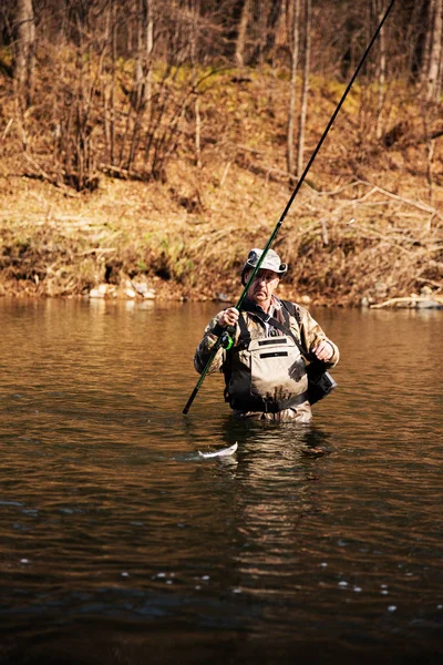 Pescador feliz puxa pego cinzento — Fotografia de Stock