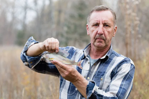 Pescador demuestra grayling atrapado — Foto de Stock