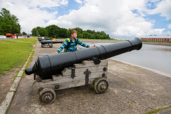 Niño parado cerca de un viejo cañón en Kronstadt, Rusia —  Fotos de Stock