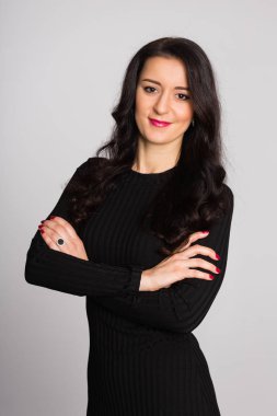 Gri bir arka plan üzerinde siyah elbiseli güzel esmer