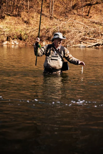 Fischer fängt Äsche aus Fluss — Stockfoto